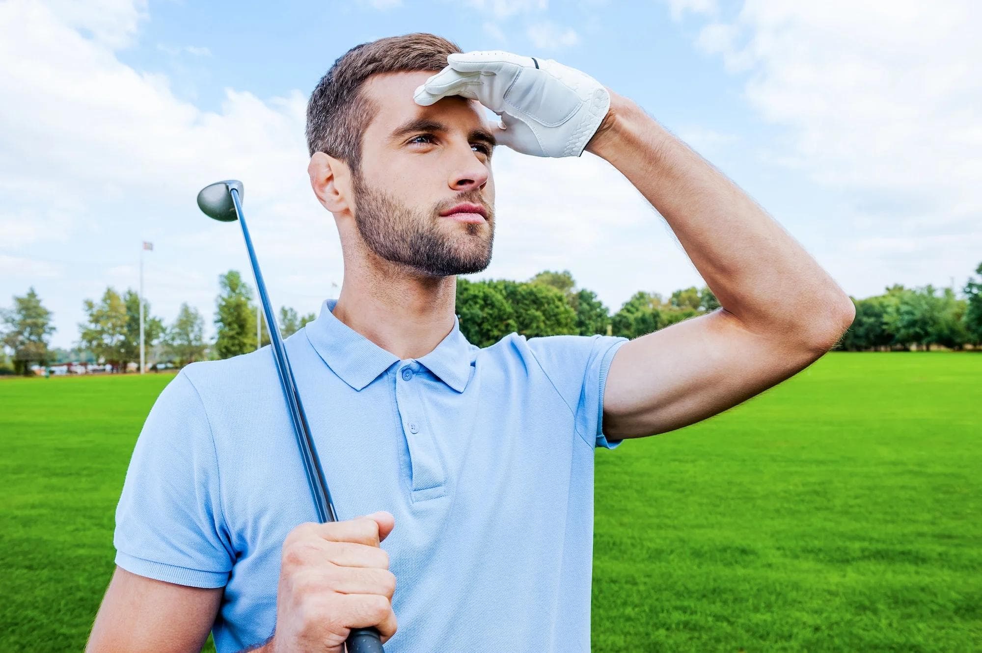 Golfer searching along the edge of a fairway